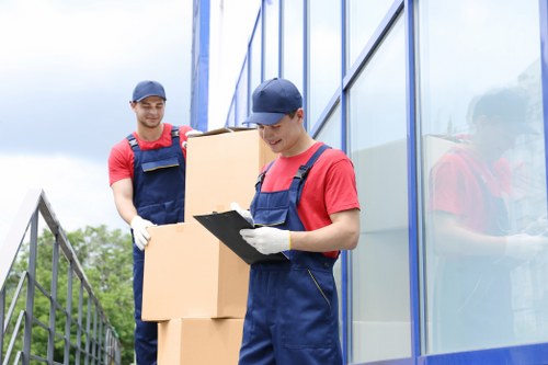 Professional movers carrying a sofa through a Battersea property stairwell